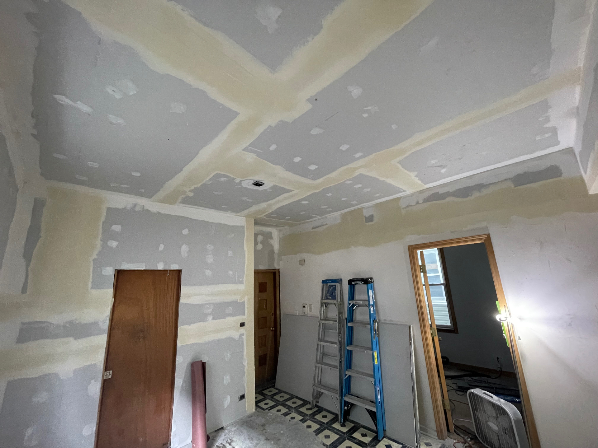 Room with taped and mudded drywall seams on walls and ceiling by R&M Drywall