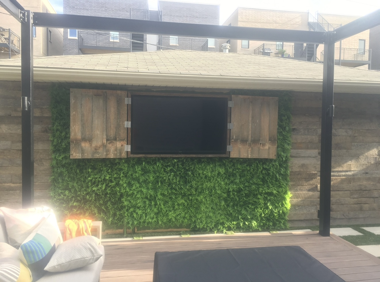 Finished outdoor feature wall with wood paneling and greenery