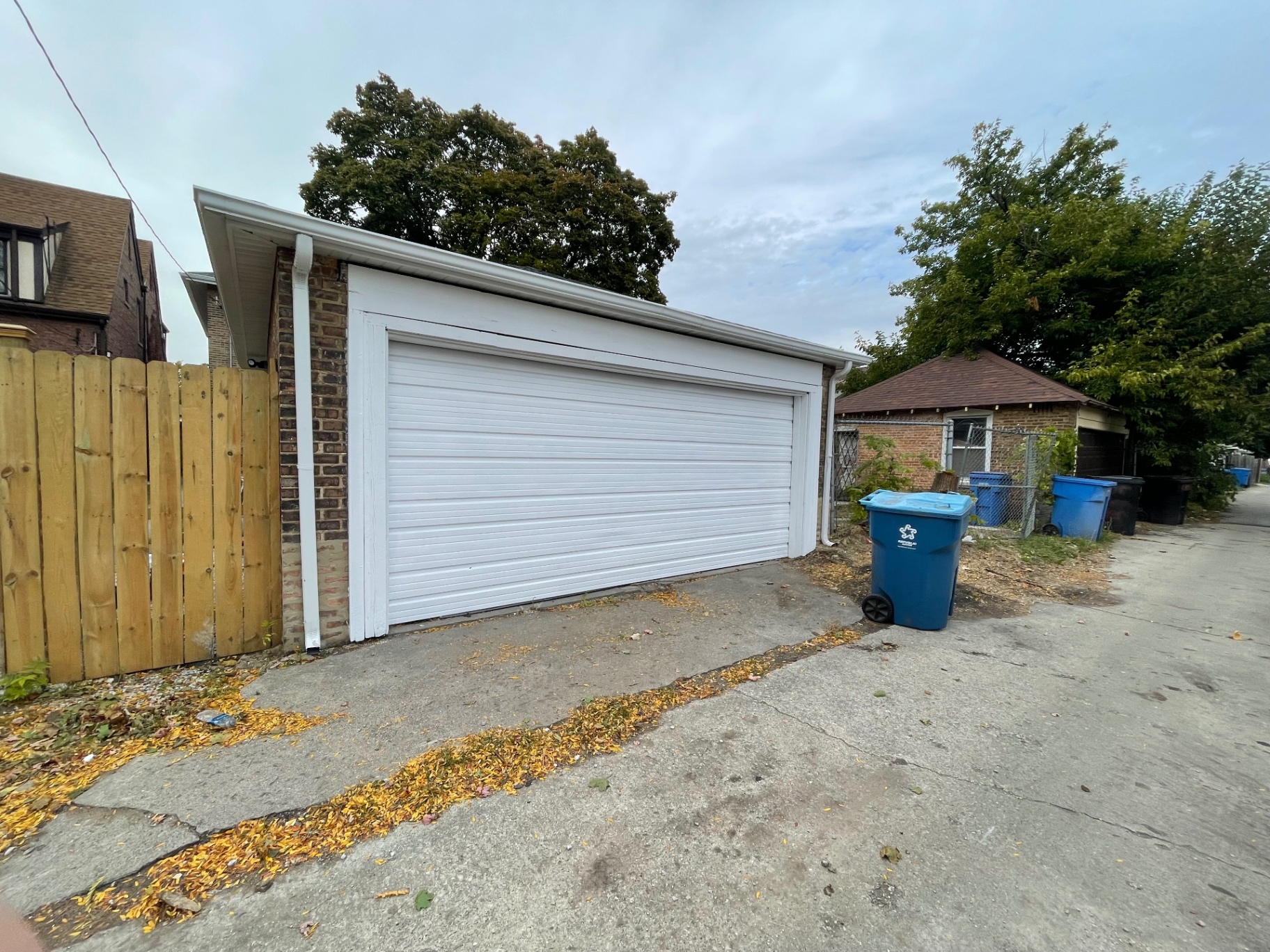 Refreshed garage exterior with clean white trim and bright white garage door by R&M Drywall