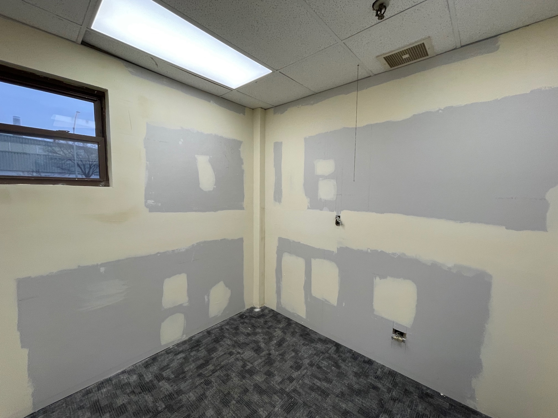 Office corner walls skim coated with joint compound ready for sanding