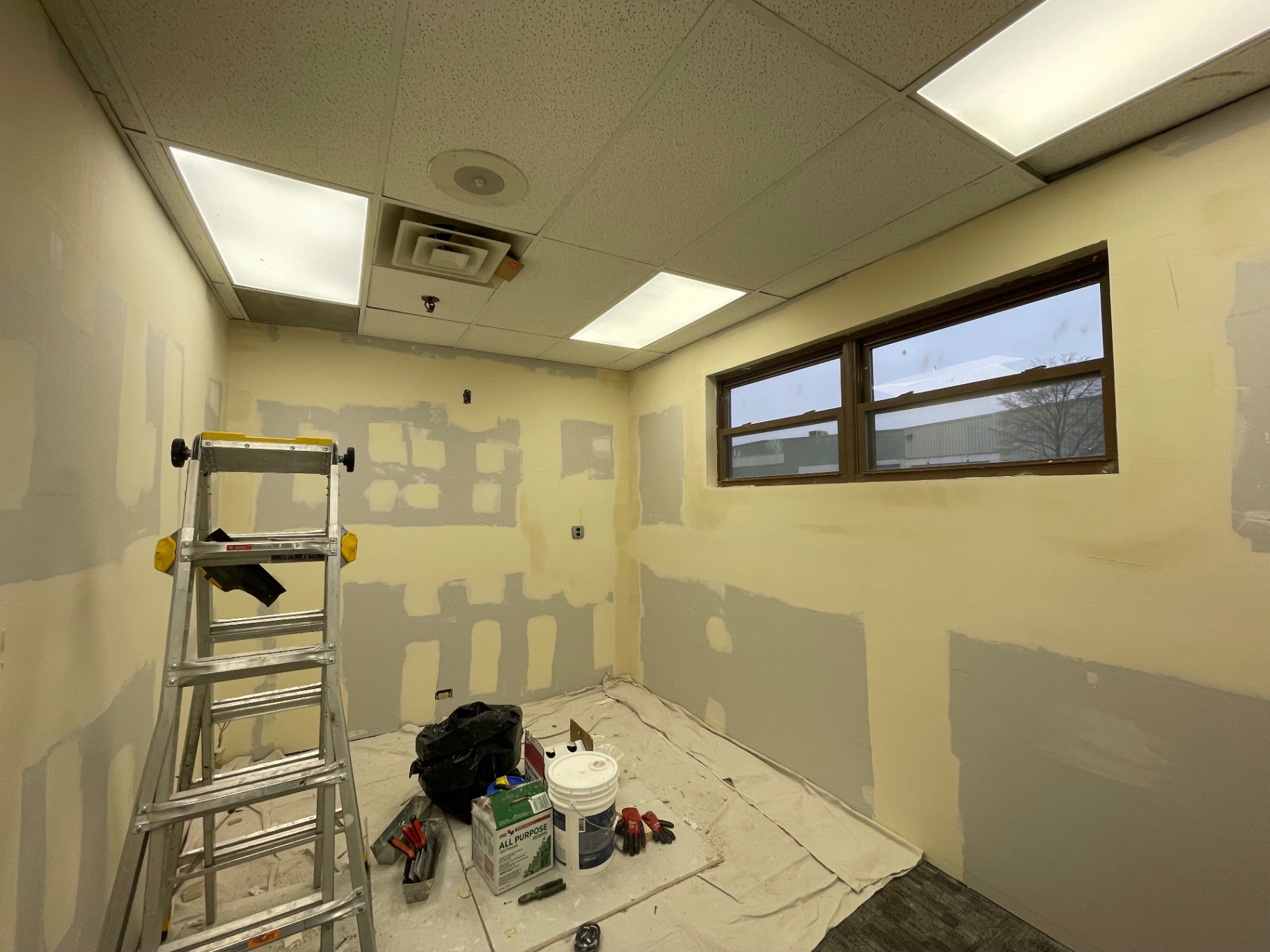 Office walls with fresh joint compound patches during taping and mudding