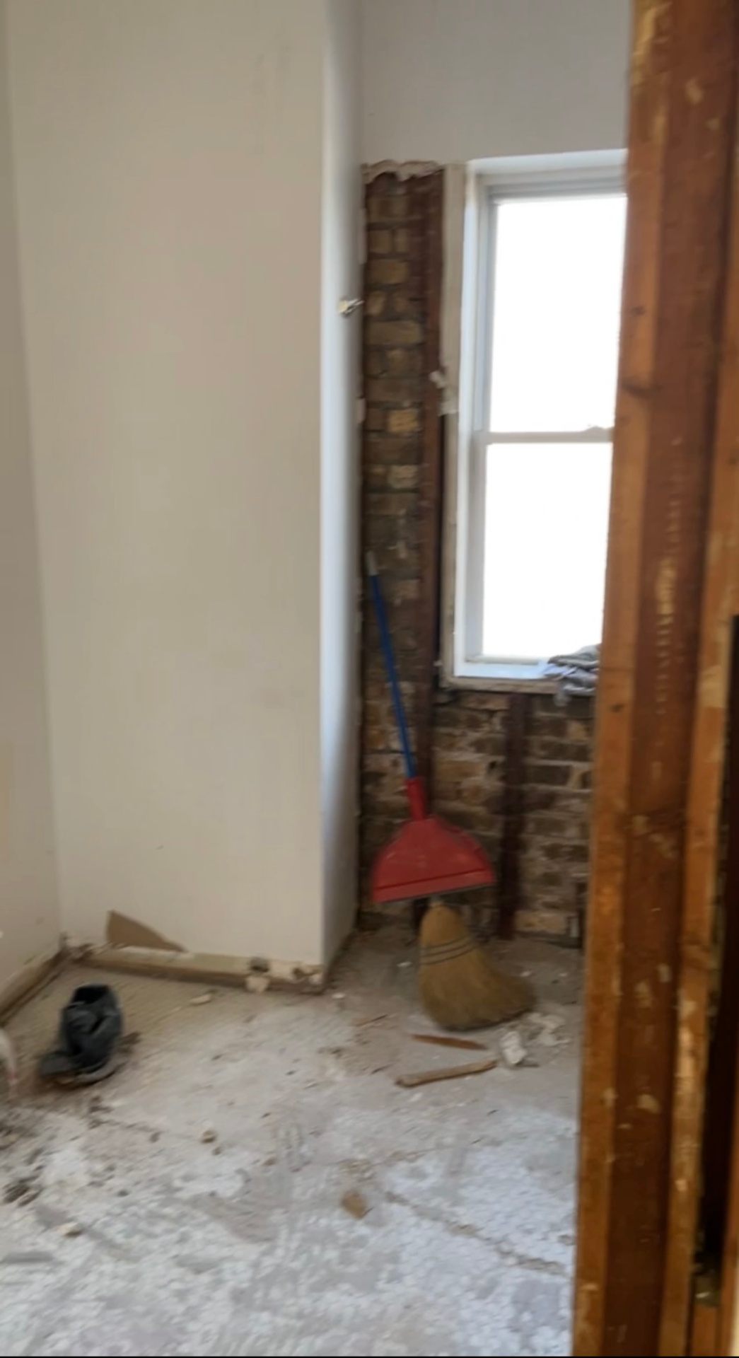 Room stripped to brick and framing before drywall installation